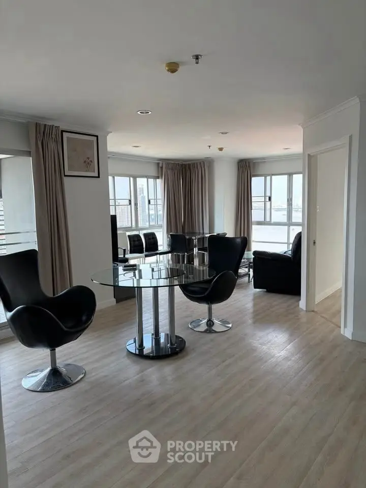 Modern living room with sleek furniture and large windows offering ample natural light.