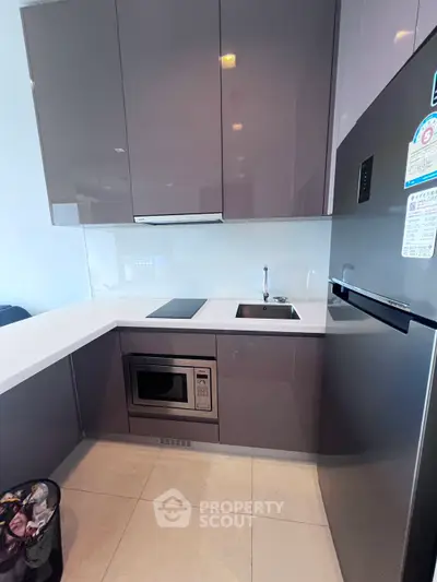 Modern kitchen with sleek cabinetry, built-in oven, and compact design ideal for urban living.