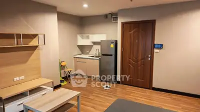 Modern studio apartment with compact kitchen and wooden flooring