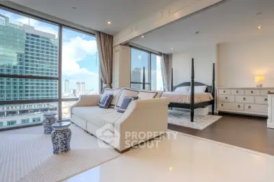 Luxurious open-plan living room and bedroom with stunning city views in modern high-rise apartment.