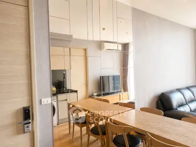Modern living room with mirrored wall, sleek dining table, and cozy seating area.