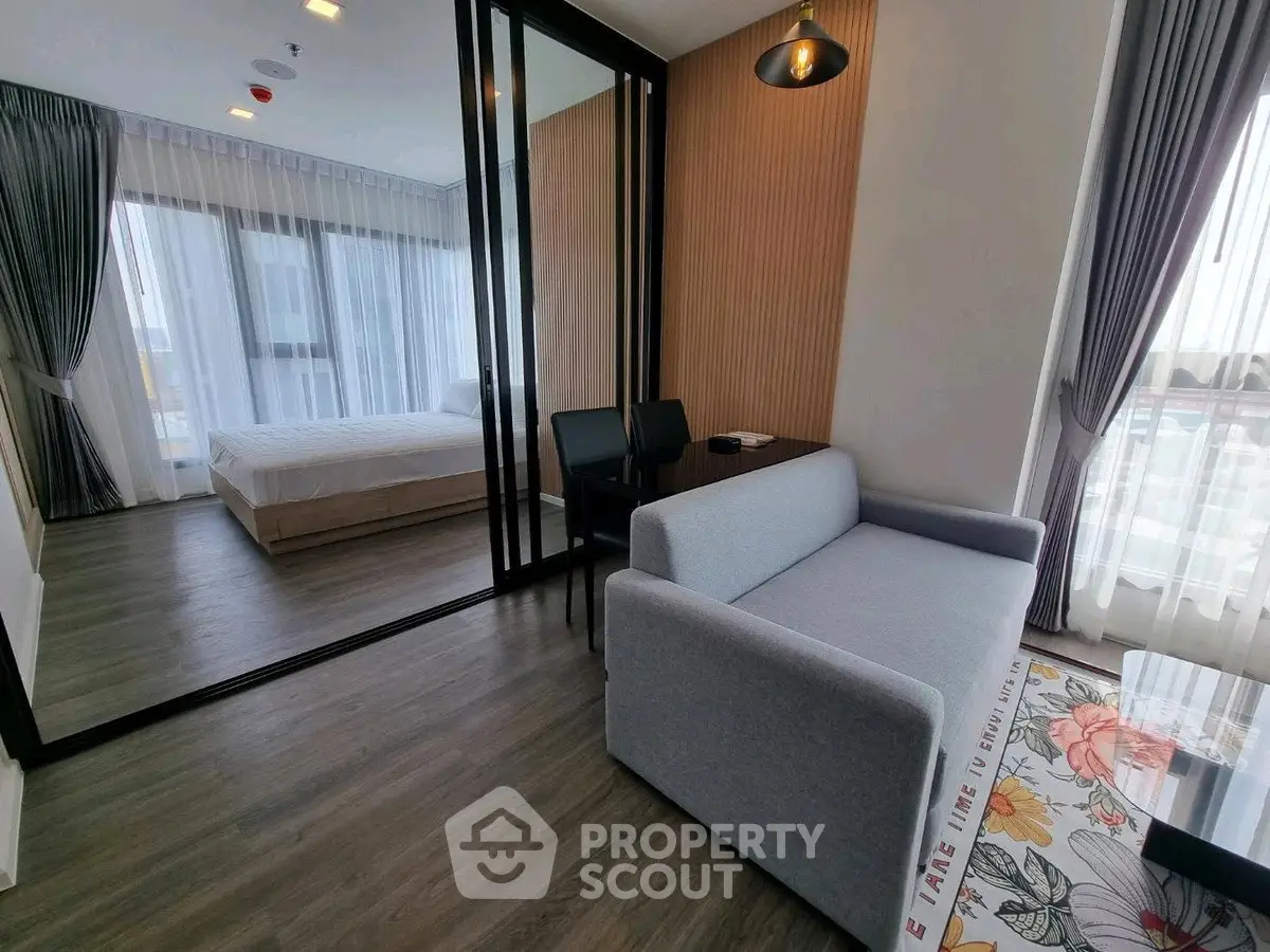 Modern apartment with stylish living room and bedroom, featuring floor-to-ceiling windows and elegant decor.