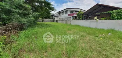 Spacious residential plot with lush greenery and adjacent modern homes.