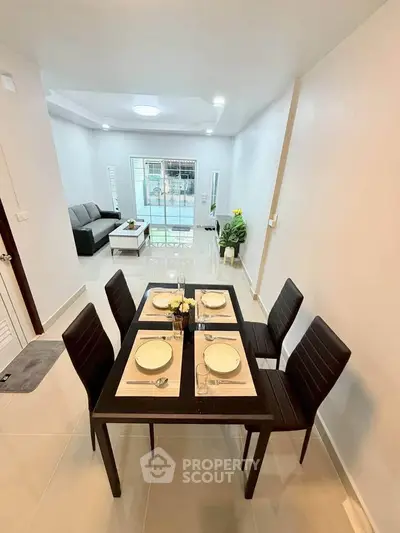 Modern dining and living area with sleek furniture and bright lighting in a contemporary home.