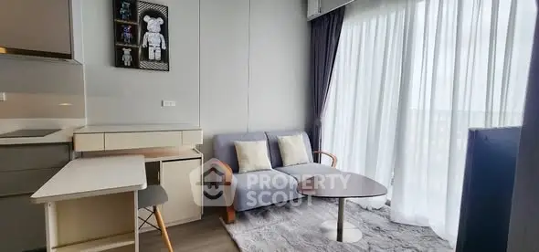 Modern living room with cozy sofa and large window, perfect for relaxation.