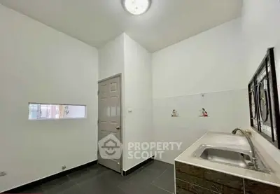 Spacious kitchen with modern sink and sleek design in a bright, minimalist setting.