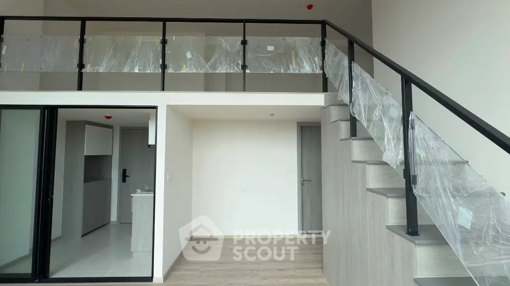 Modern duplex apartment with sleek staircase and open mezzanine level