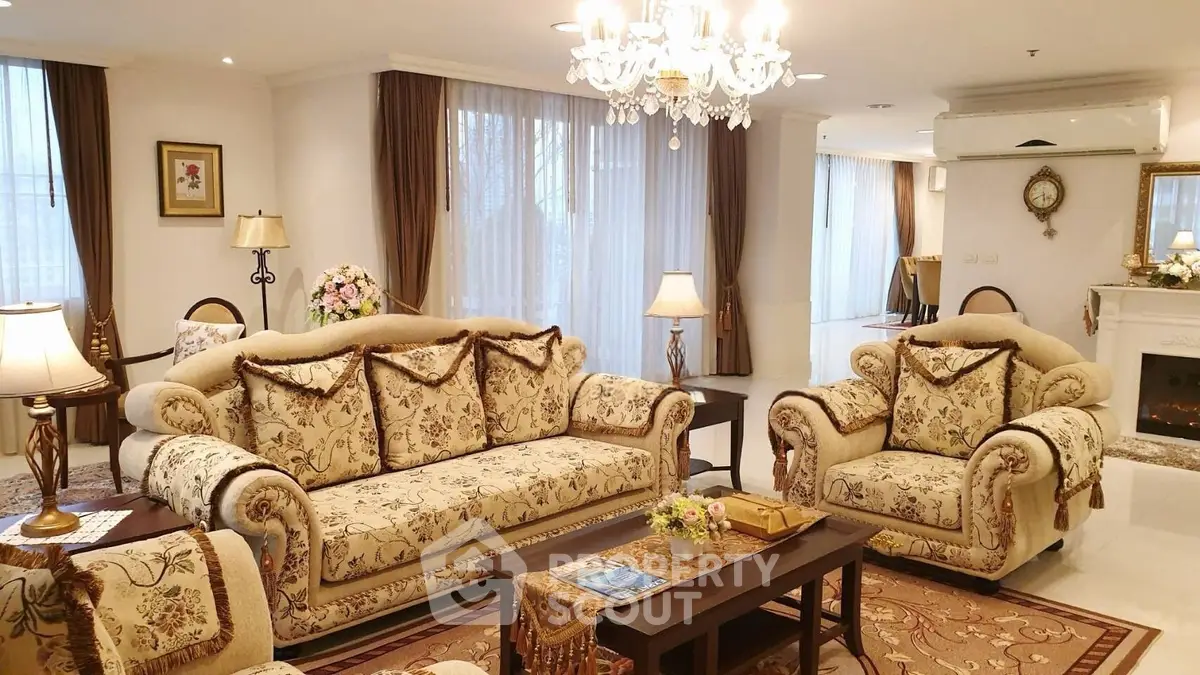 Luxurious living room with elegant floral sofas and chandelier lighting