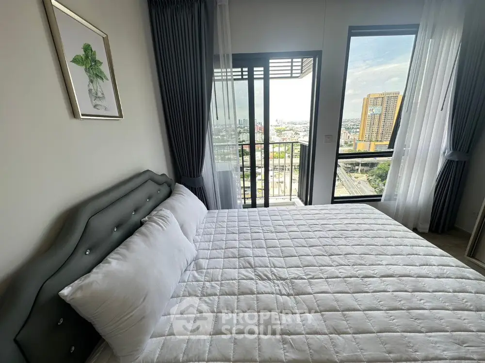 Modern bedroom with balcony and city view, featuring elegant decor and natural light.