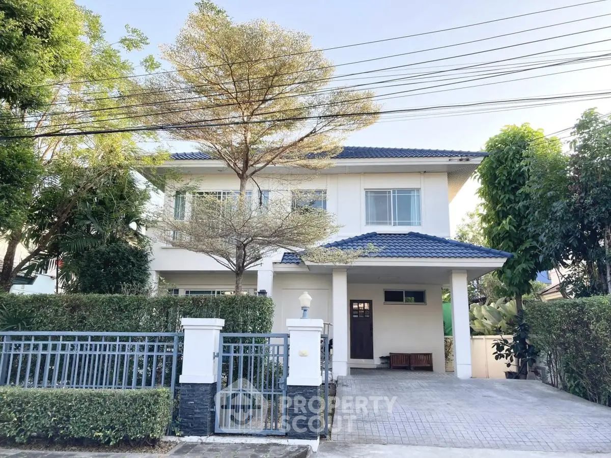 Charming two-story house with lush greenery and spacious driveway in a serene neighborhood.