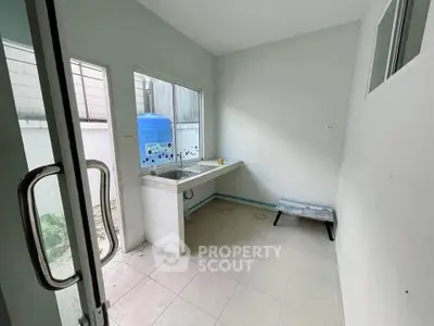 Compact kitchen area with sink and outdoor view, ideal for efficient cooking space.