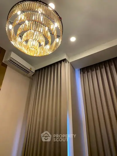 Luxurious interior with elegant chandelier and modern curtains, perfect for upscale living spaces.