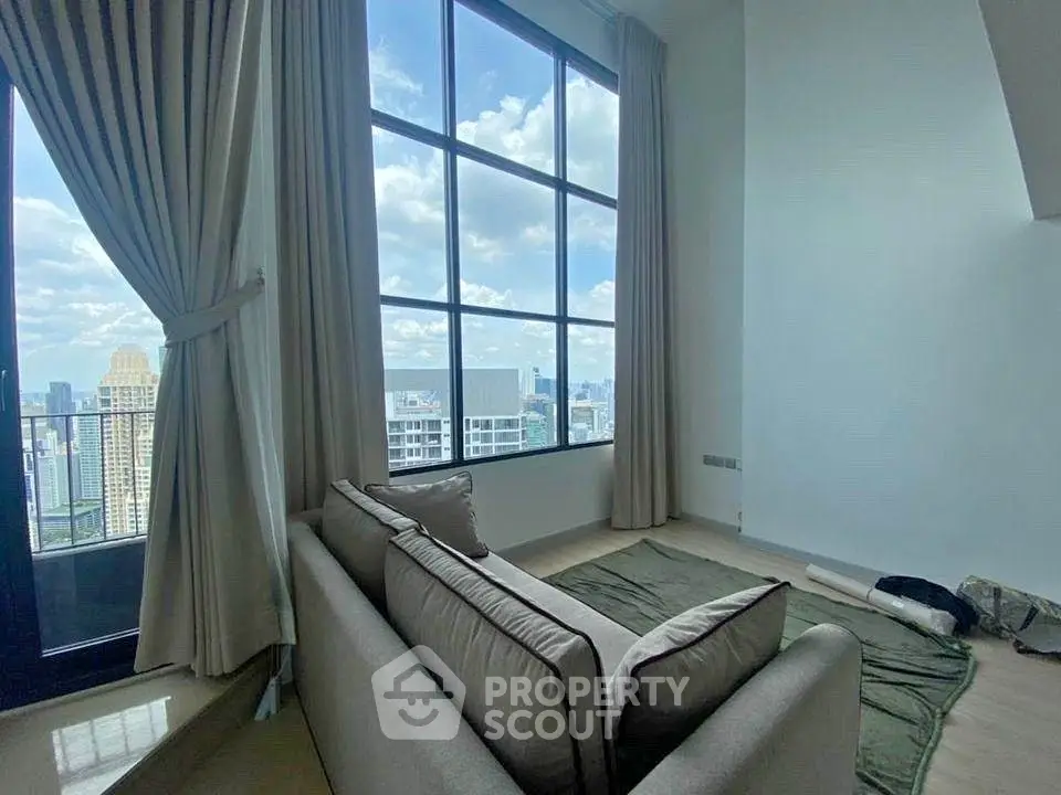 Luxurious high-rise living room with stunning city skyline view and elegant decor.