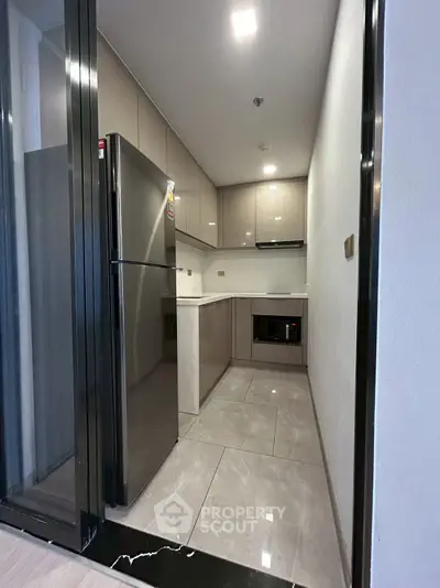 Modern kitchen with sleek cabinets and stainless steel appliances in a compact layout.