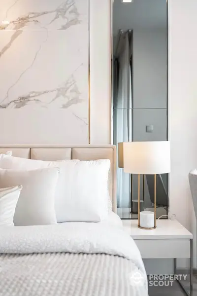 Luxurious modern bedroom with elegant marble accent wall and stylish lamp