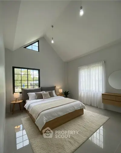 Spacious modern bedroom with high ceiling and large windows