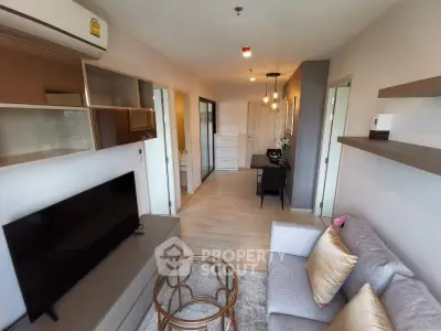 Modern living room with stylish decor and open layout, featuring a cozy sofa and sleek TV setup.