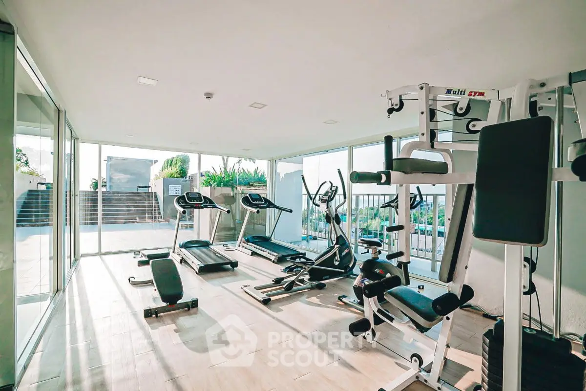 Modern gym with state-of-the-art equipment and large windows offering natural light.
