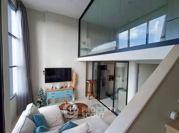 Modern loft apartment with high ceilings and stylish decor, featuring a cozy living area and mezzanine bedroom.