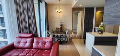 Modern living room with red leather sofa and elegant dining area in luxury apartment.