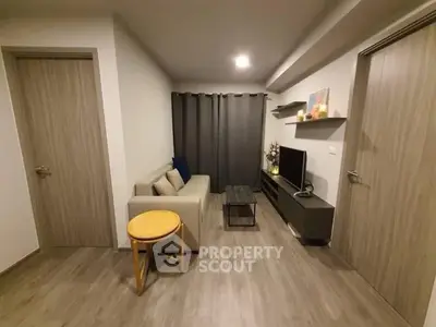 Modern living room with cozy sofa, TV unit, and stylish decor in a compact space.