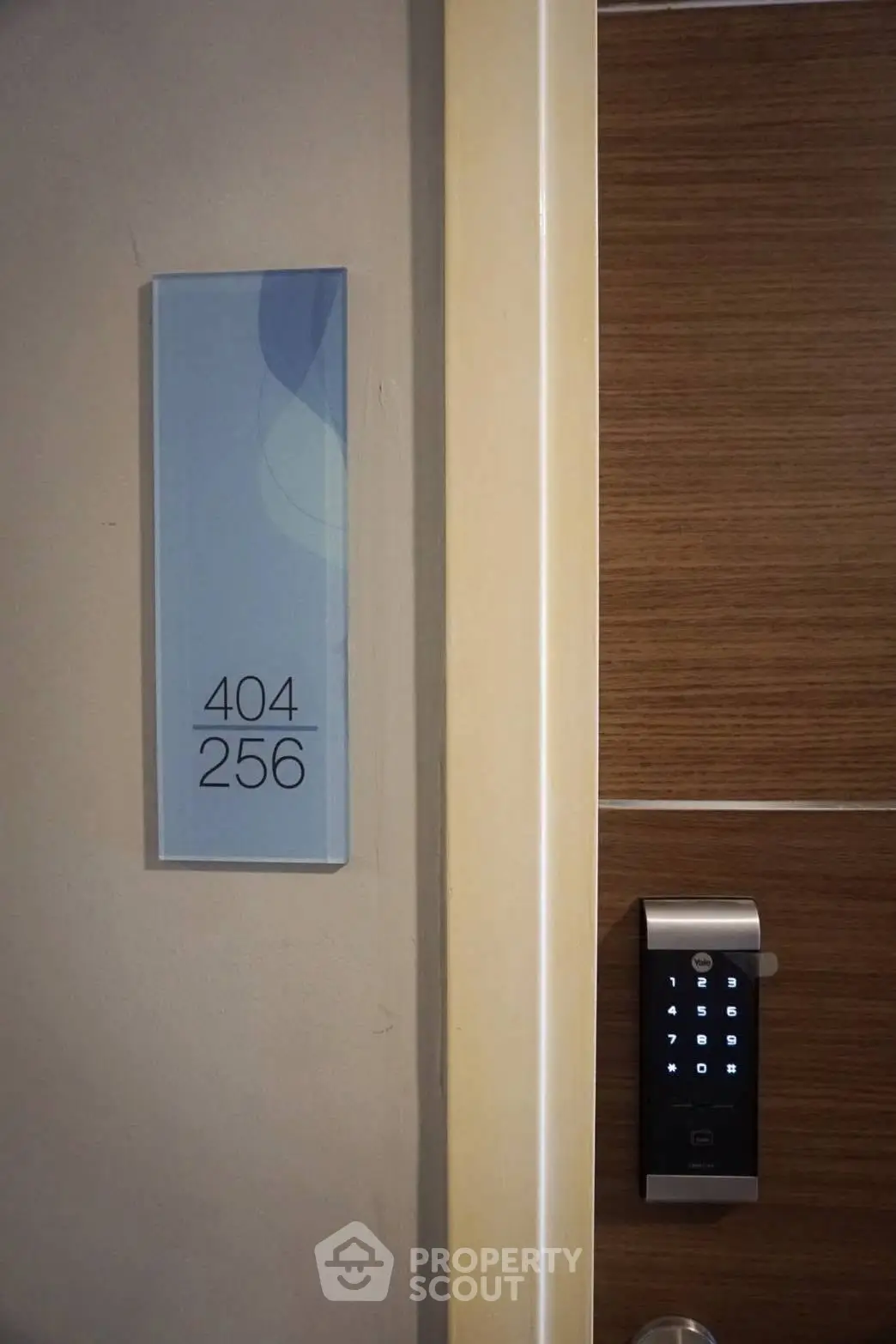 Modern apartment door with digital lock and room number sign, showcasing secure and stylish entryway.