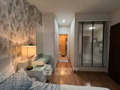 Cozy bedroom with stylish wallpaper and en-suite bathroom in modern apartment