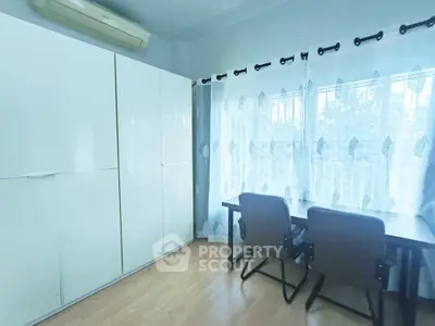 Bright study room with large windows and modern furniture, perfect for productivity.