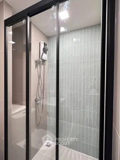 Modern bathroom with sleek glass shower enclosure and stylish tile design.