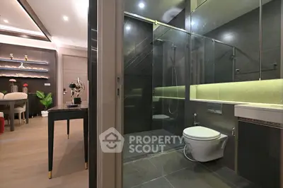 Luxurious modern bathroom with sleek glass shower and elegant dining area view.