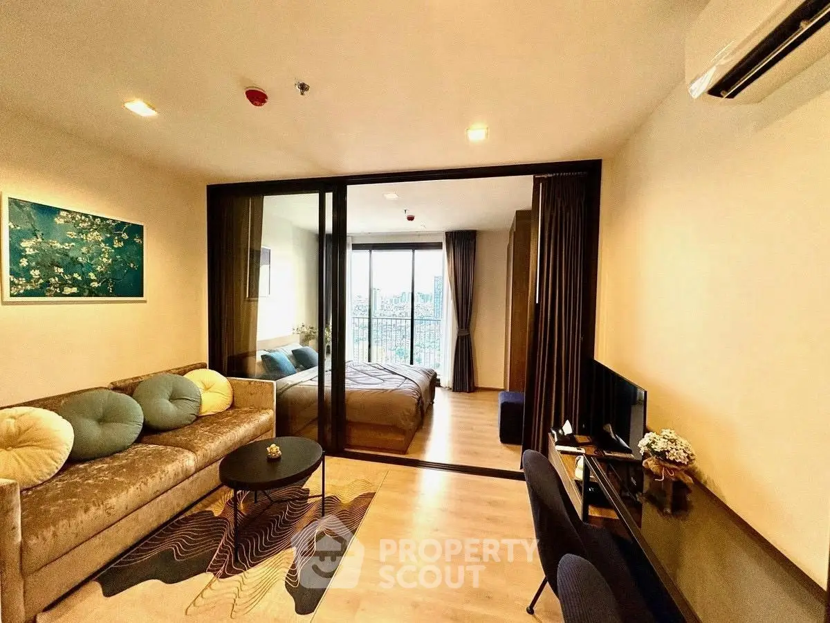 Stylish modern apartment with open living room and bedroom, featuring elegant decor and city view.