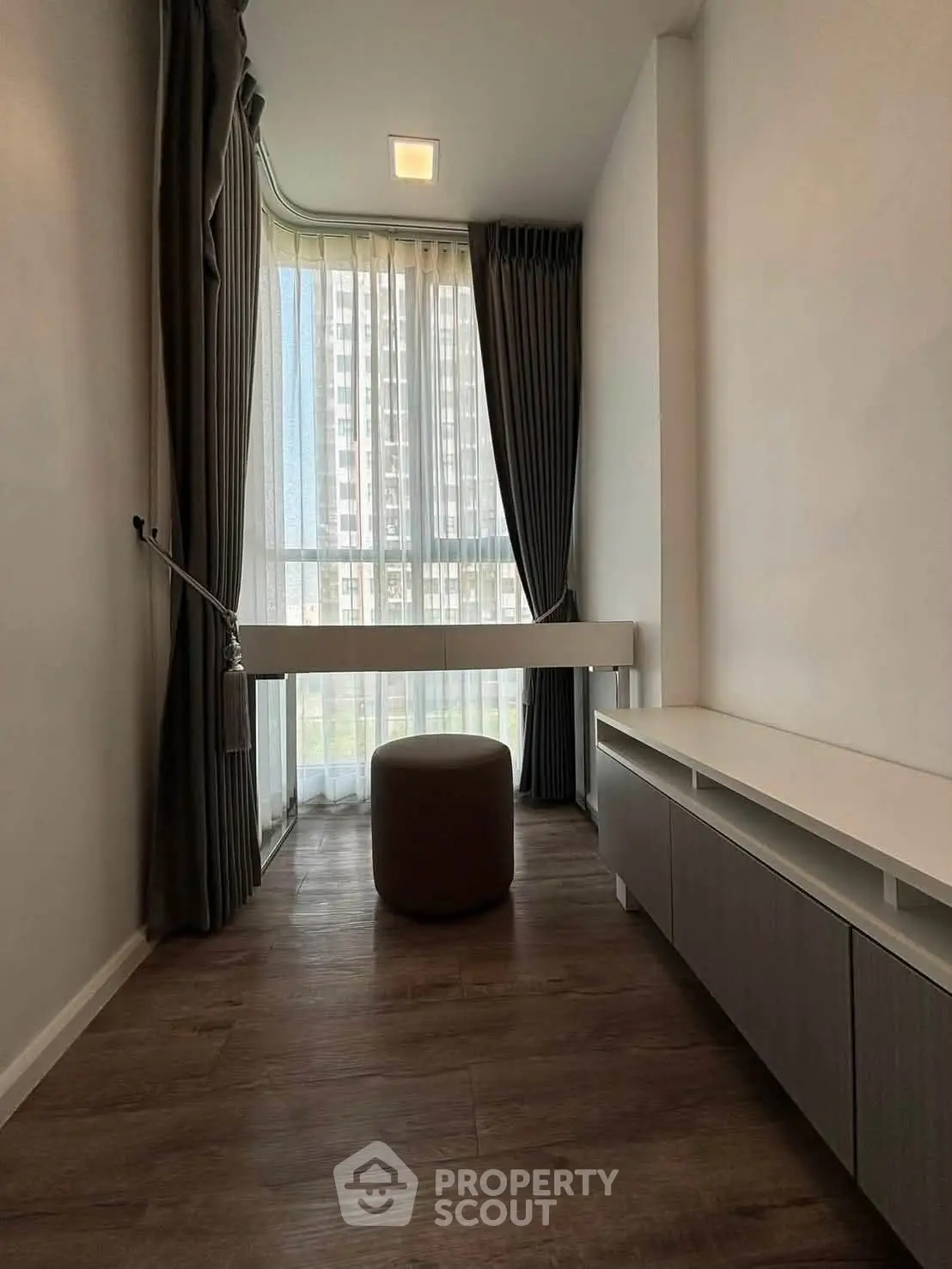 Modern minimalist room with floor-to-ceiling window and elegant curtains, perfect for a cozy reading nook.