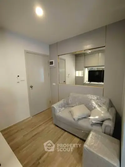 Modern compact living room with sleek design and cozy furniture, perfect for urban living.