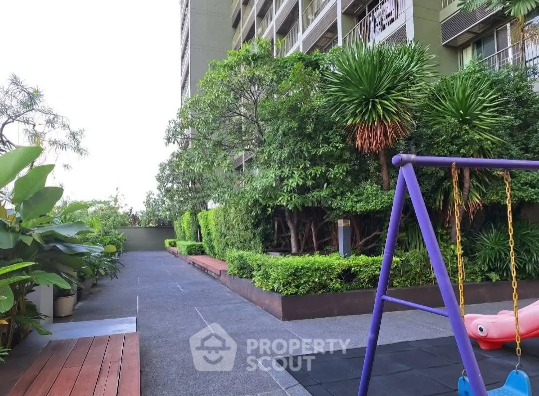Modern apartment building with lush garden and children's play area