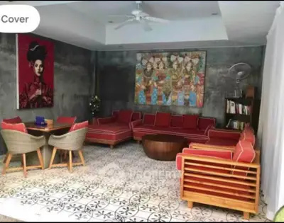 Stylish living room with vibrant red furniture and artistic decor in a modern home.