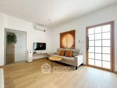 Modern living room with sleek furniture and natural light, featuring a cozy sofa and stylish decor.
