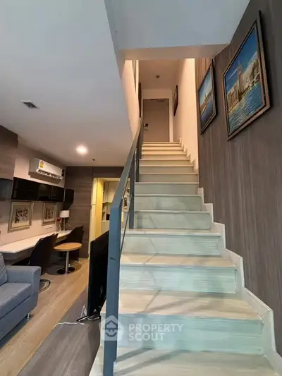 Modern duplex apartment with stylish staircase and cozy living area, perfect for urban living.