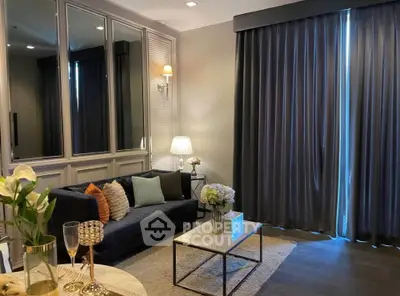 Elegant living room with plush sofa, stylish decor, and floor-to-ceiling curtains.