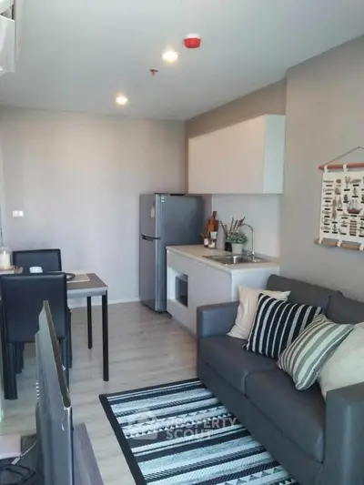 Modern open-layout living room with kitchen, stylish decor, and cozy seating area.