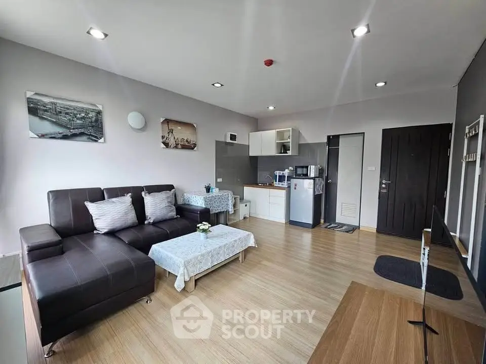 Modern living room with sleek furniture and open kitchen layout in a stylish apartment.
