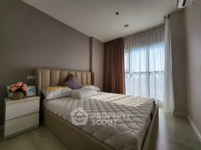 Cozy bedroom with large window and modern decor in a stylish apartment.