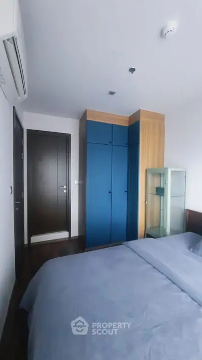 Modern bedroom with blue wardrobe and sleek design