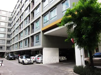 Modern apartment building with parking area and lush greenery