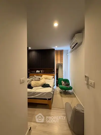 Cozy bedroom with modern decor and air conditioning, featuring a comfortable bed and stylish seating area.