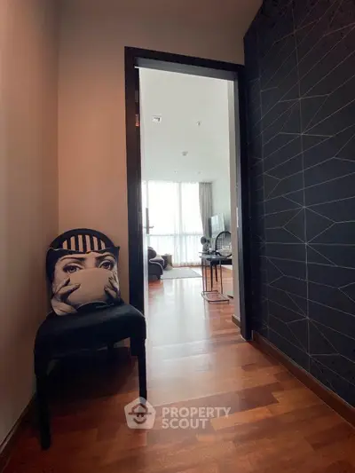 Stylish interior hallway leading to a modern living room with wooden flooring and chic decor.