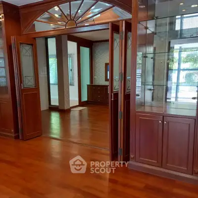 Spacious interior with elegant wooden flooring and glass cabinets, perfect for a luxurious living room setup.