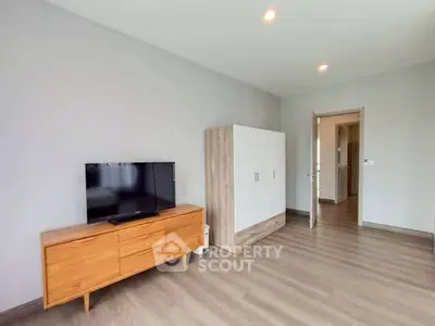 Spacious modern living room with wooden flooring and sleek furniture, perfect for contemporary living.