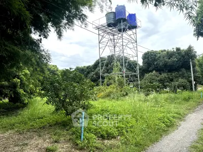 Lush green landscape with water tower, ideal for serene living or agricultural development.