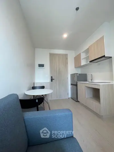 Modern compact studio apartment with sleek kitchen and cozy living area