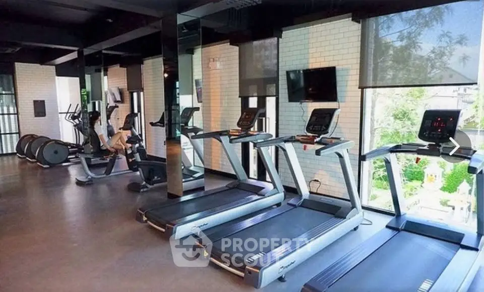 Modern gym with treadmills and fitness equipment in a luxury residential building.